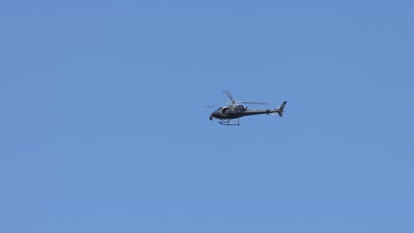 a helicopter progresses through a sunny, cloud-dotted sky