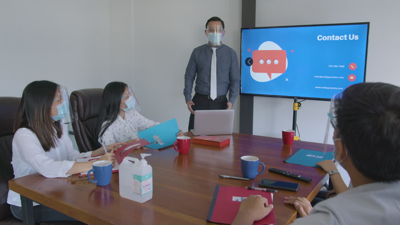 안면 마스크, 안면 보호대 및 알코올을 근처에서 착용하는 회원과의 새로운 정상적인 기업 회의