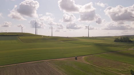 wind park in the fields of rhineland palatinate, germany underneath a bright blue sky with soft cumulus clouds