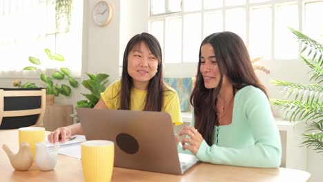 two young women working on a laptop