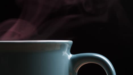 close up hot coffee cup with nature steam smoke of coffee on wooden table, black background with copy space. coffee and tea drink concept.