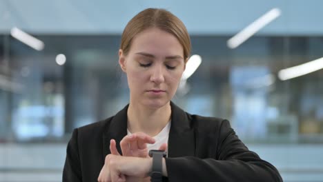 mujer de negocios que usa un reloj inteligente para obtener información
