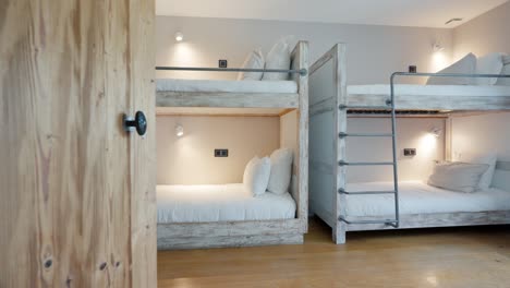 opening a door to reveal a stylishly decorated bunk bed room at domaine sainte colombe, france, showcasing a blend of modern design and comfort, ideal for concepts of chic accommodations