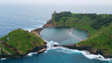 aerial ocean lagoon green hills landscape. calm waves washing vegetated island