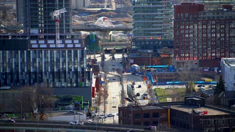 Busy-intersection-in-city-downtown-with-bridge-in-background---Cherry-Street-and-Front-Street-East-in-Toronto,-Ontario,-Canada