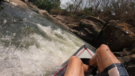 pov de un hombre en una canoa en un pequeño río con agua rápida casi colapsando