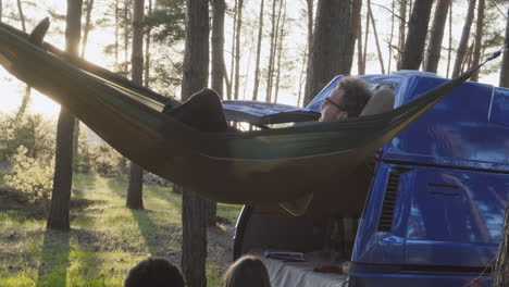 a multiethnic group of friends lying in hammocks in the forest