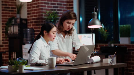 Worker-in-brick-wall-office-requesting-assistance-from-team-leader