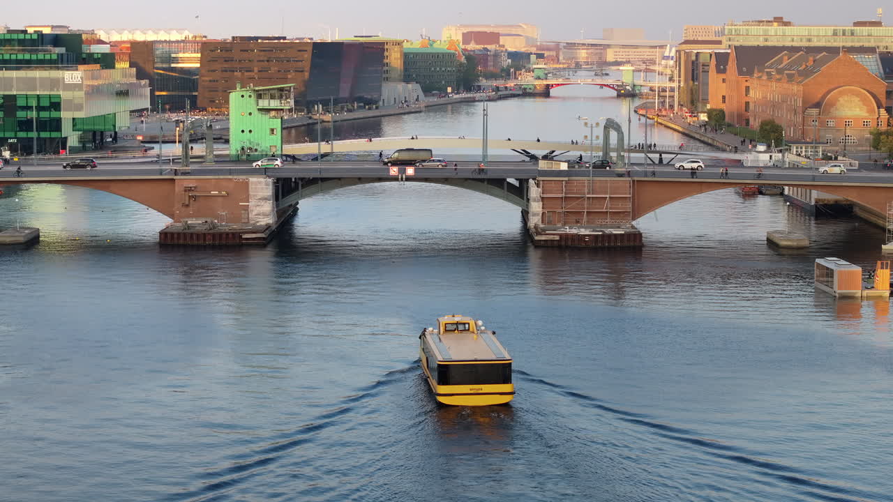 Aerial drone view of a yellow boat moving on the water in the Teglholmen peninsula in the South Harbour of Copenhagen, Denmark