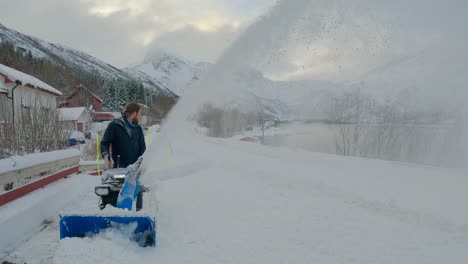 Toma-Estática-De-Un-Hombre-Limpiando-Nieve-Con-Un-Gran-Soplador-De-Nieve-Durante-El-Invierno-En-El-Norte-De-Europa