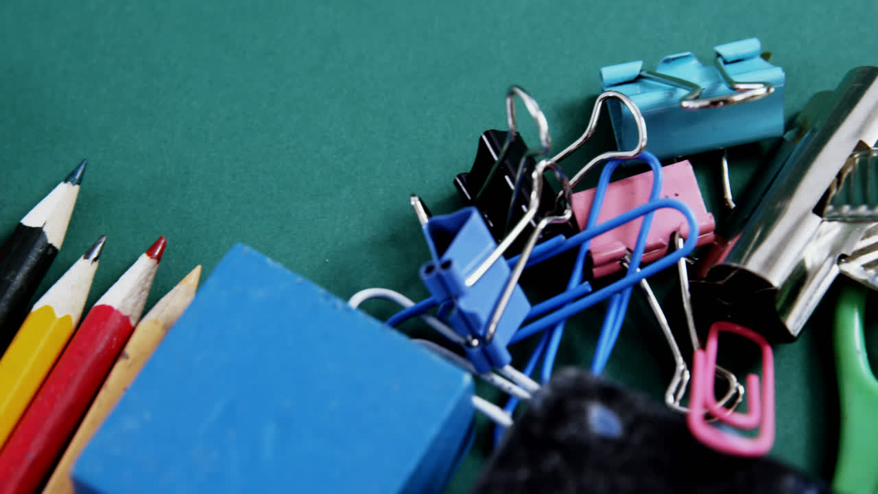 초록색 배경 에 배열 된 학교 용품