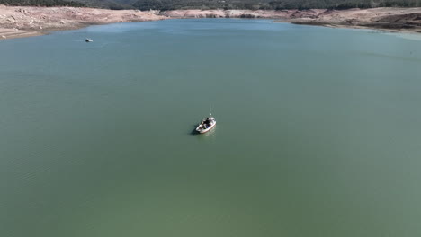 Fishing-boats-on-Sau-dam-with-low-water-level,-Catalonia