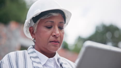 woman in hard hat using tablet