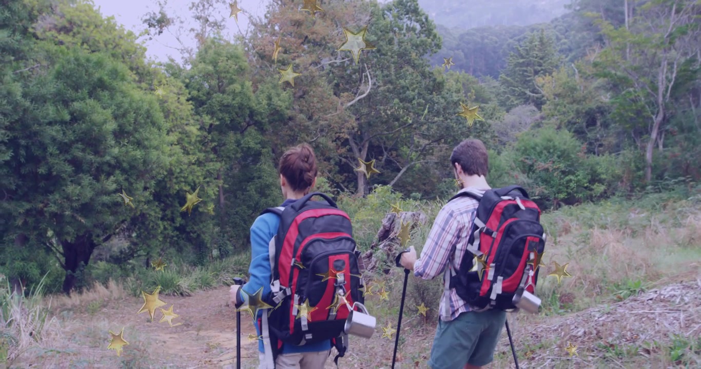 Hikers tightening backpack straps and adjusting poles, walking along misty outdoor forest trail