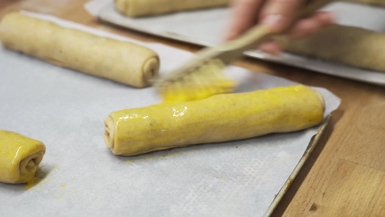 기 전에 반이는 색을 얻기 위해 굴러진 베글리 반죽 줄기에 달을 는 손의 클로즈업