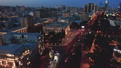 flying above districts of baku modern downtown and busy streets at night, azerbaijan