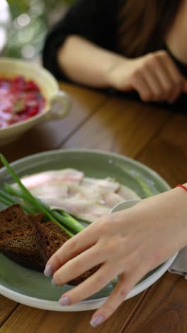 woman eating a meal with bread and salted meats