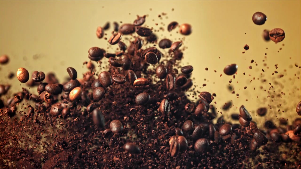 Chicchi di caffè tostati e macinato che esplodono al rallentatore