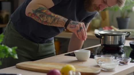 bearded man crushing spices with mortar and pestle