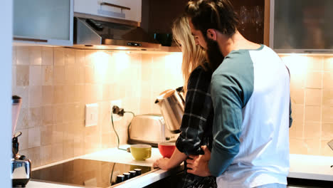 couple interacting while having coffee in kitchen 4k