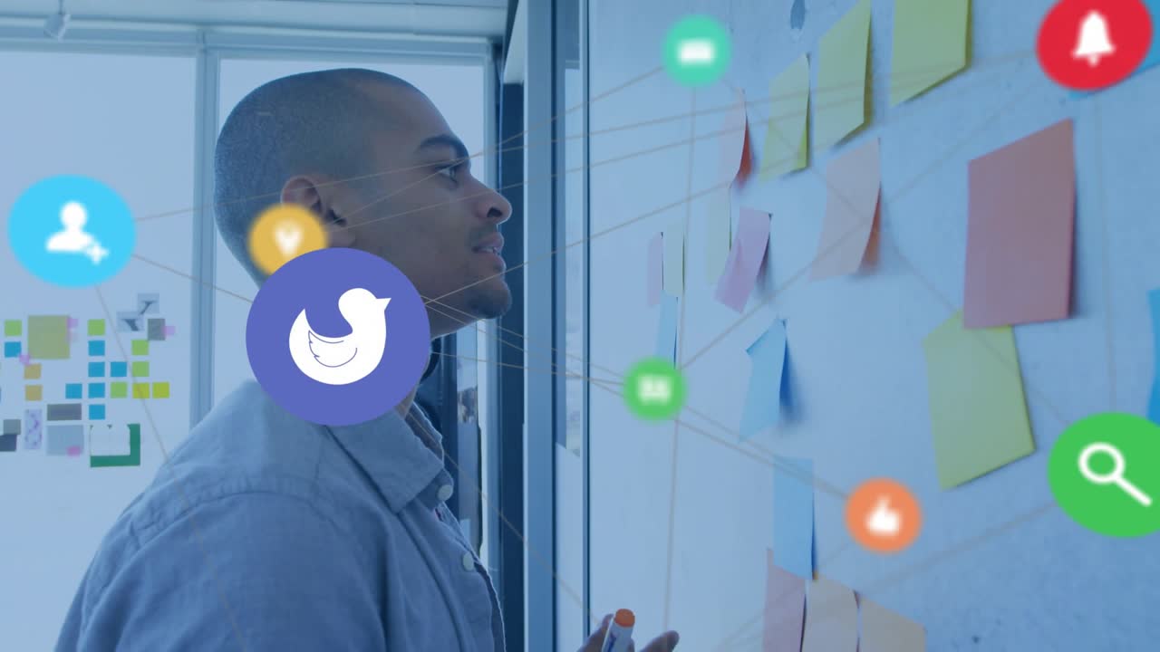 Man tracing lines and reading Post-its, icons appearing overlaying while peeling notes for design