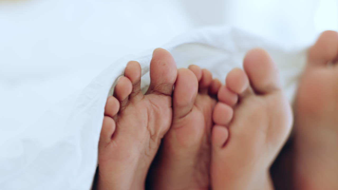 Couple, relax and feet in bed together on holiday