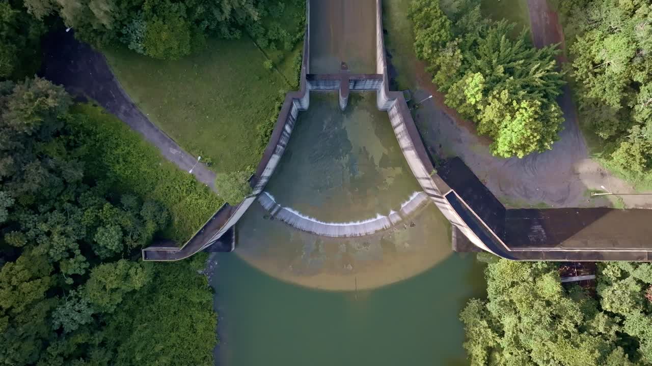 Hatillo Dam water reserve in Dominican Republic. Aerial top down landing shot. Tropical forest and barrier.