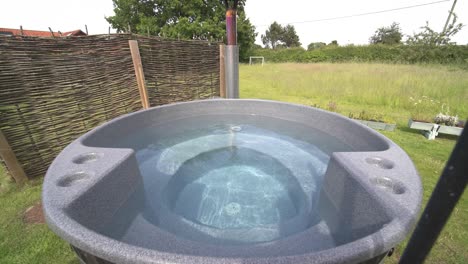 Wide-reveal-of-wood-fired-cedar-hot-tub-on-private-secluded-glamping-camping-site-in-Yorkshire-england