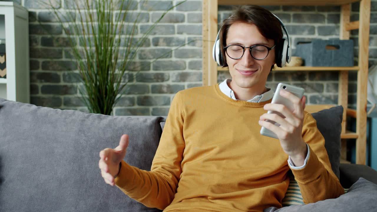 Young Man Enjoying Music on Smartphone at Home