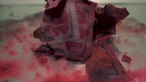 Blood-Money-slowly-splatter-moving-close-up-one-hundred-dollar-bills-cash-isolated-with-shallow-depth-of-field