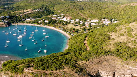 Sonnige-Luftaufnahme-Des-Englischen-Hafens-In-Antigua,-Karibik-Mit-Blick-Auf-Yachten,-Segelboote,-Marina,-Bucht-Und-Klippen