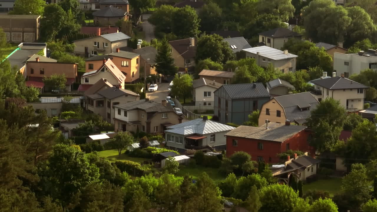 Telephoto drone shot of a suburban community of homes, sunny day in Latvia