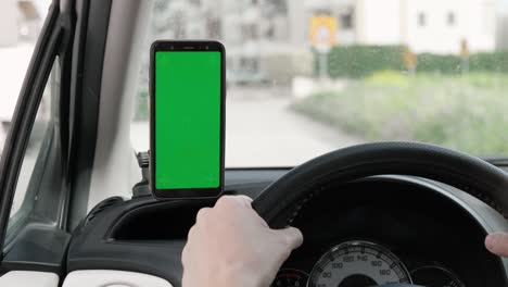 una maqueta de teléfono inteligente de pantalla verde dentro del coche durante la conducción.