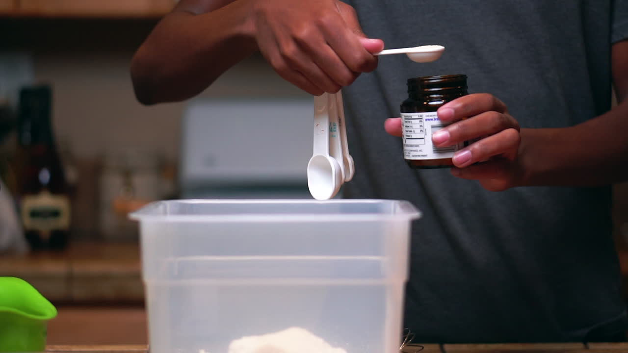 medir la levadura con una cucharadita para agregar a la harina para hacer masa o masa