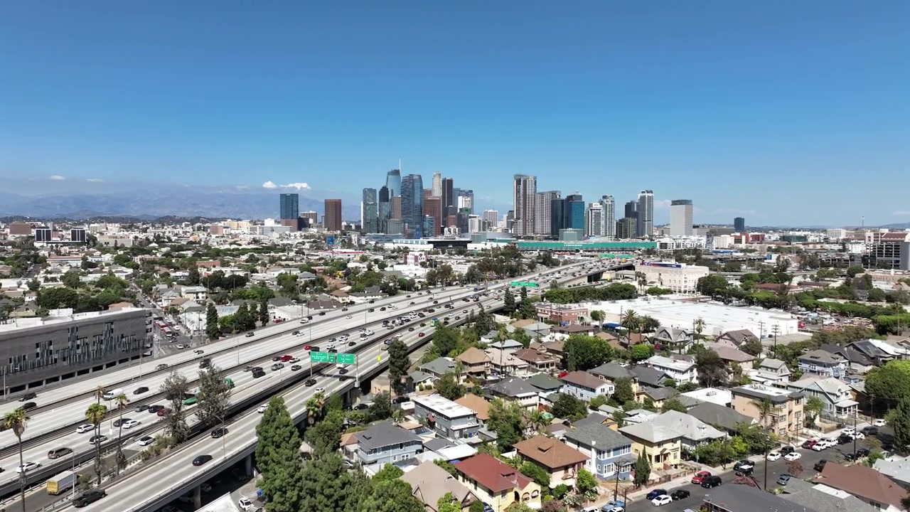 Riprese aeree di Downtown Los Angeles con alti edifici commerciali, architettura di grattacieli e uno skyline urbano denso posizionato accanto alla trafficata autostrada 110