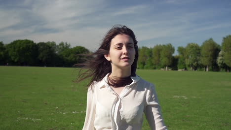 Portrait-of-a-fashionable-and-beautiful-Italian-model-walking-in-a-tranquil-park-wearing-a-transparent-shirt-in-London,-United-Kingdom