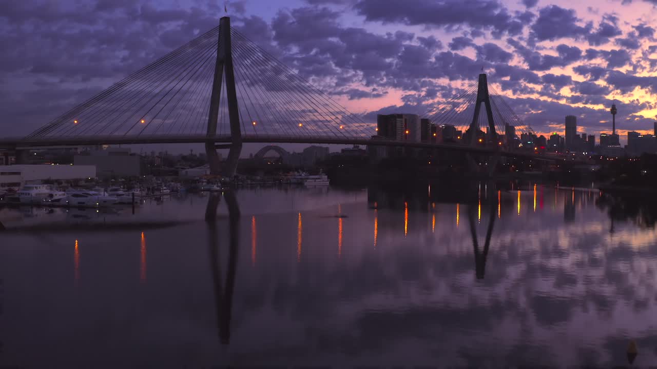 Drone aerial view of traffic flowing over a suspended bridge across a river