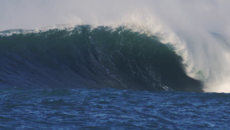 large ocean wave forming at golden hour, with sunlight illuminating the crest and deep blue water