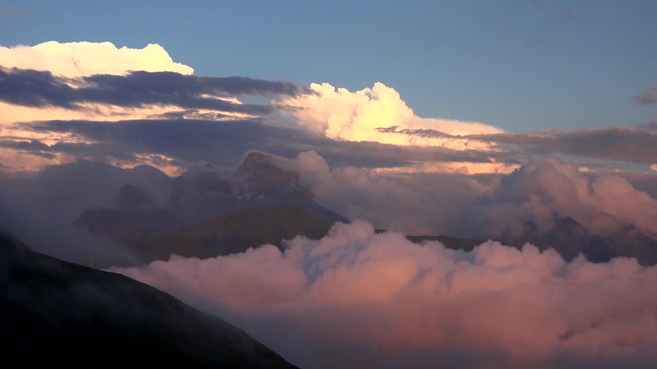 Majestic Mountain Peaks Rising Above Thick Clouds at Sunset