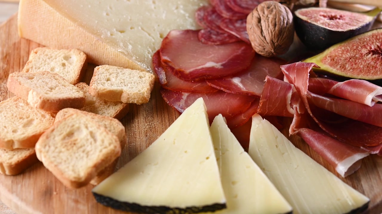 Tagliere di salumi e formaggi con formaggio, uva e fichi.