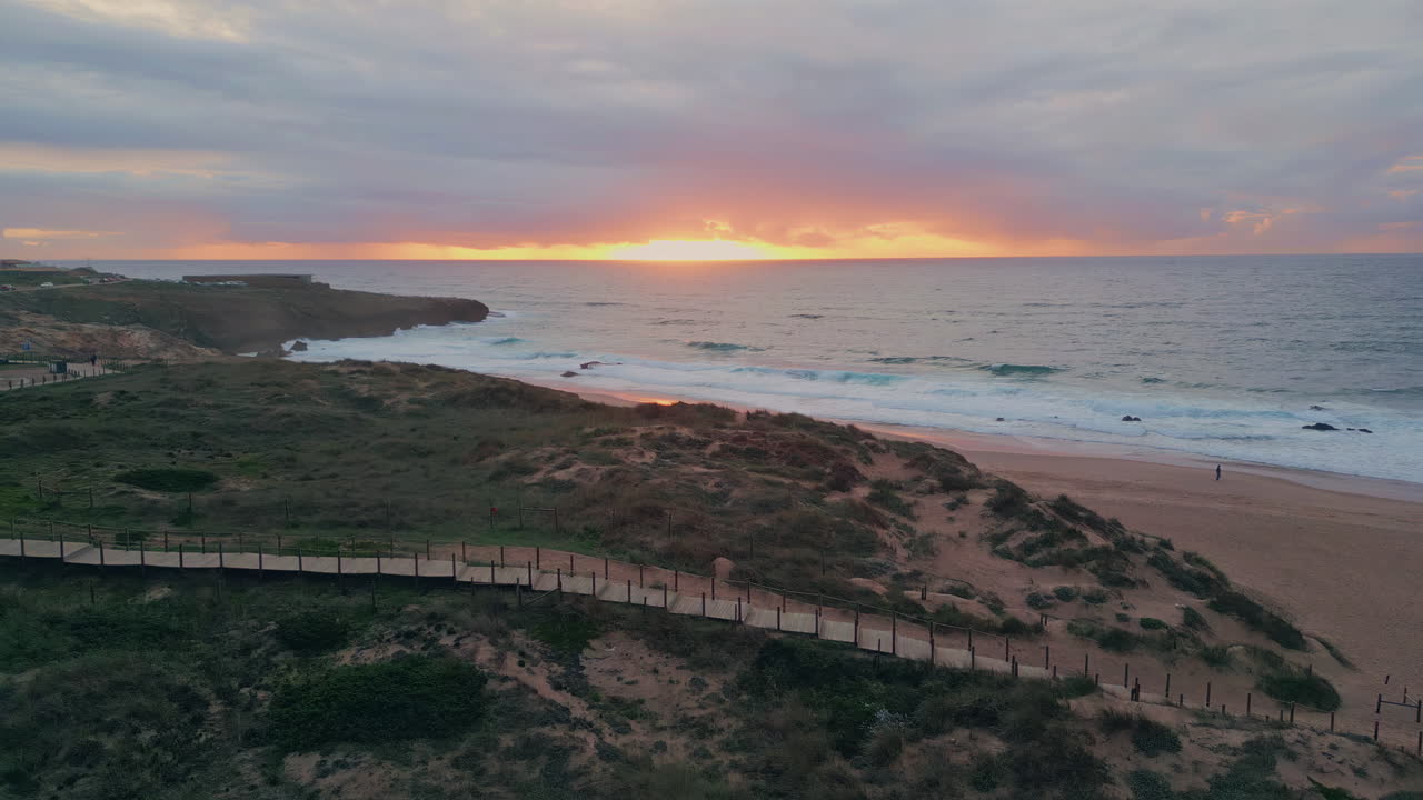 Amazing golden sunset ocean coast aerial view. Evening sea waves at sandy shore