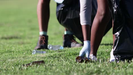 Cropped-shot-of-people-picking-bottles-in-bags