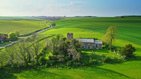 Drone-footage-reveals-Burwell-village,-formerly-a-medieval-market-town,-bordered-by-rural-fields,-traditional-red-brick-dwellings,-and-the-abandoned-Saint-Michael-parish-church-atop-Lincolnshire