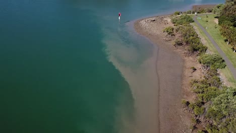 Drone-aerial-pan-up-over-harbour-town-on-sunny-day