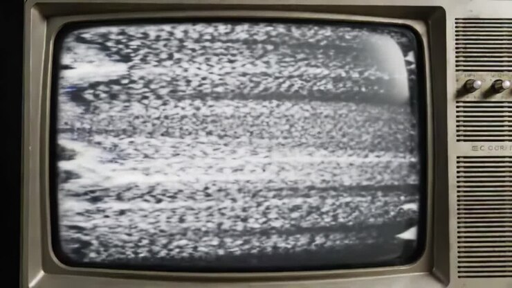 Uno schermo televisivo vintage che mostra immagini statiche distorte, evidenziando il caos di segnali poco chiari e rappresentando la nostalgia delle esperienze mediatiche passate.