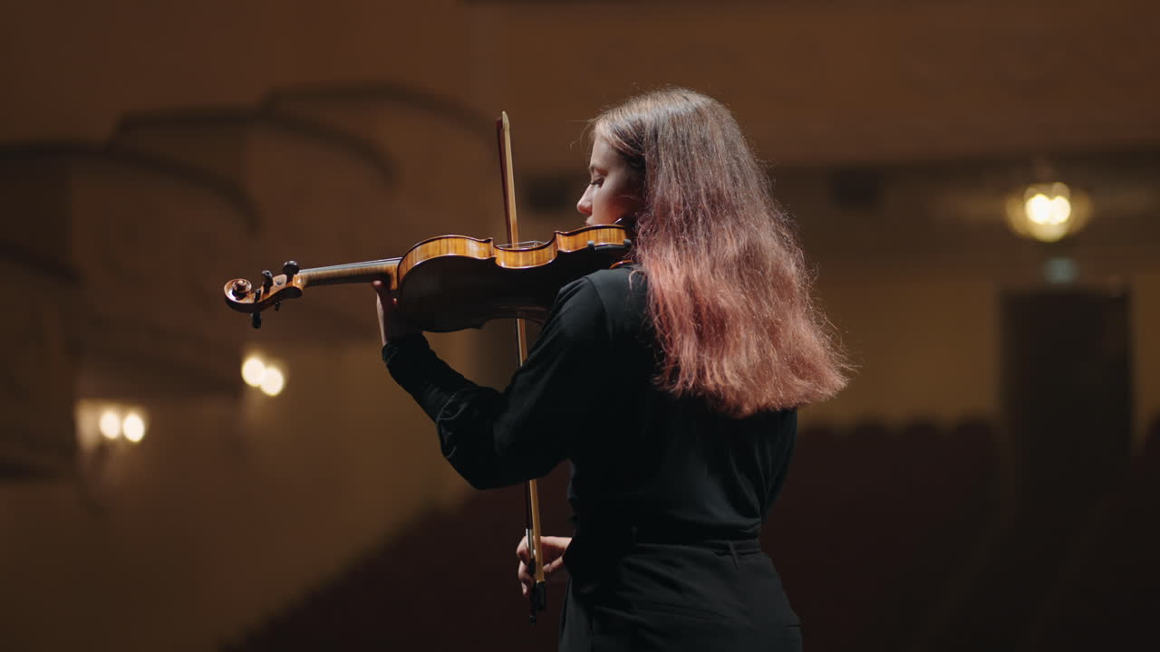 una violinista está tocando el violín en la sala de música retrato medio de un músico en la sala filarmónica