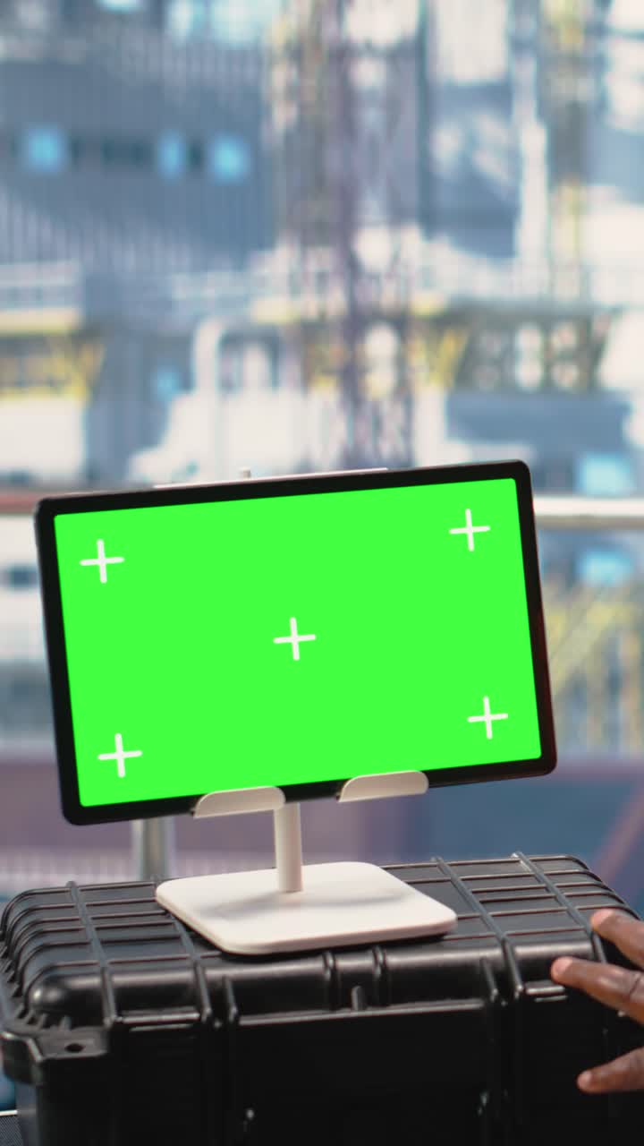 Vertical video Isolated screen tablet used by offshore platform worker supervising production