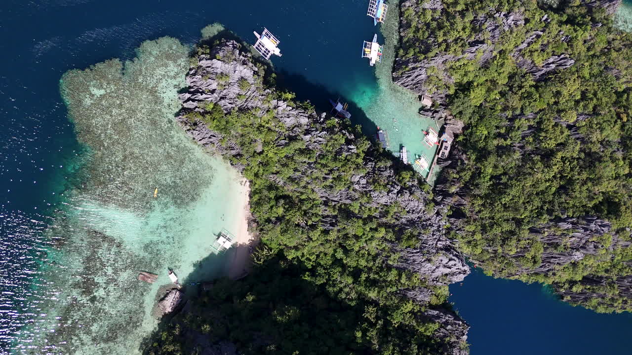 Drone view of Philippines, Coron Island’s untouched coastline, surrounded by lush forests and clear waters. Aerial view of bungalows and lagoon. Vertical video.