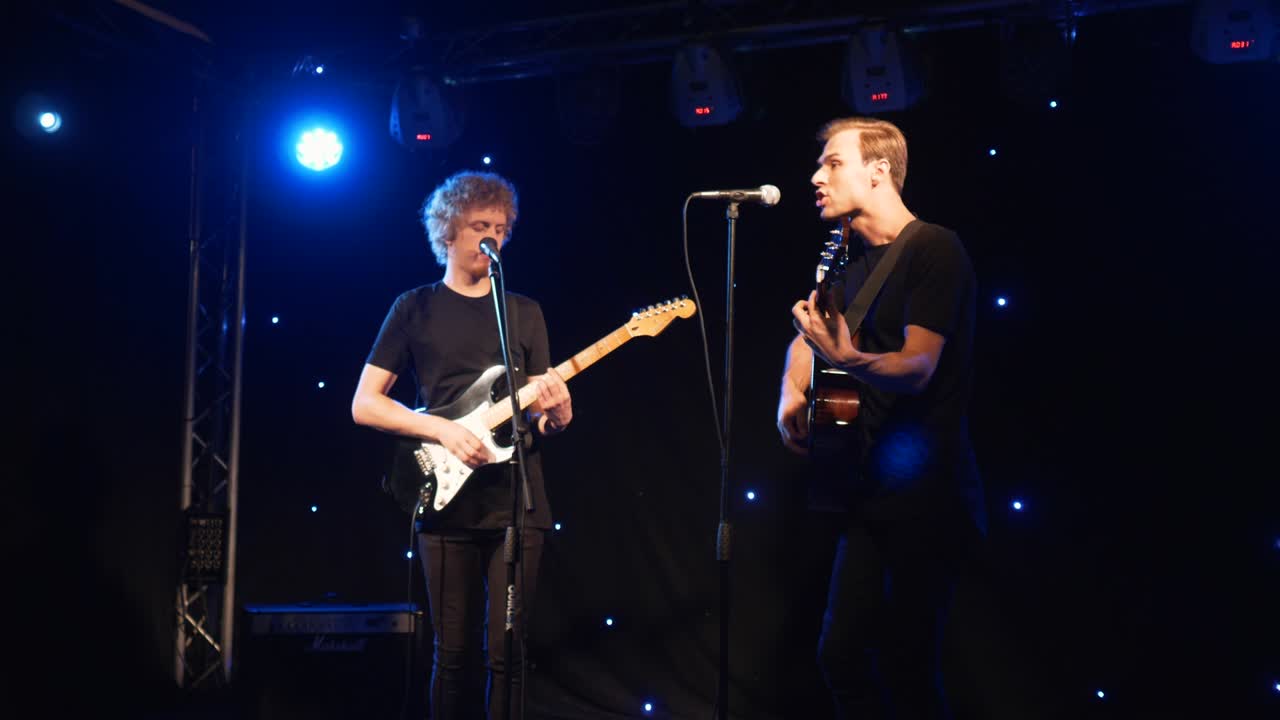 콘서트 록 밴드, 두 개의 전기 기타와 함께 무대에서 공연하는 가수, 뮤직비디오 크, 헤비 메탈 또는 록 그룹, 느린 동작 악기 연주 두 사람의 밴드