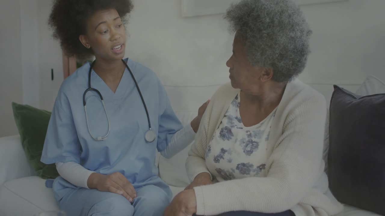 Blue-scrub nurse hand on senior woman talking starting health exam with heart rising at stethoscope